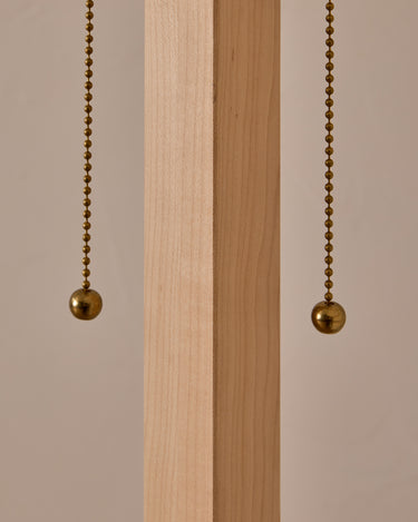 Two brass pull chains hanging against a wooden panel with a neutral background

Robert True Ogden RTO Lighting Anouck Floor Lamp  - Clear Maple#wood-finish_clear-maple 
