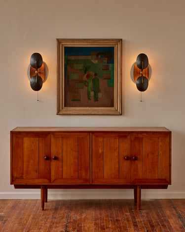 Robert True Ogden RTO Lighting - Two Greta Wall Sconce with Two Hammered Oil Rubbed Bronze Shades -Brushed Satin Brass Armature - Oval Walnut Backplate with Pull Chain in between an Oil Painting Above an Antique Wood Cradenza  