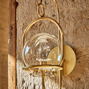 Robert True Ogden RTO Lighting - Small Emil Lantern Sconce - Brushed Satin Brass - 6" Clear Glass Globe - Hung Outside on a Concrete Wall#finish_brushed-satin-brass